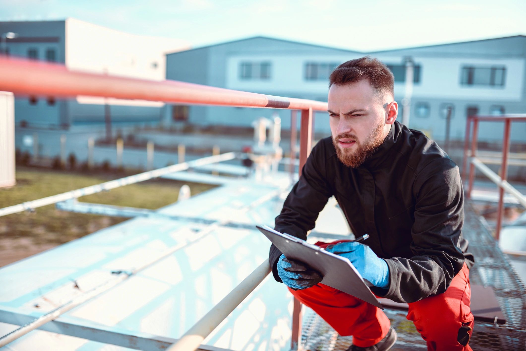 Technician inspecting equipment and writing notes, representing compliance checks