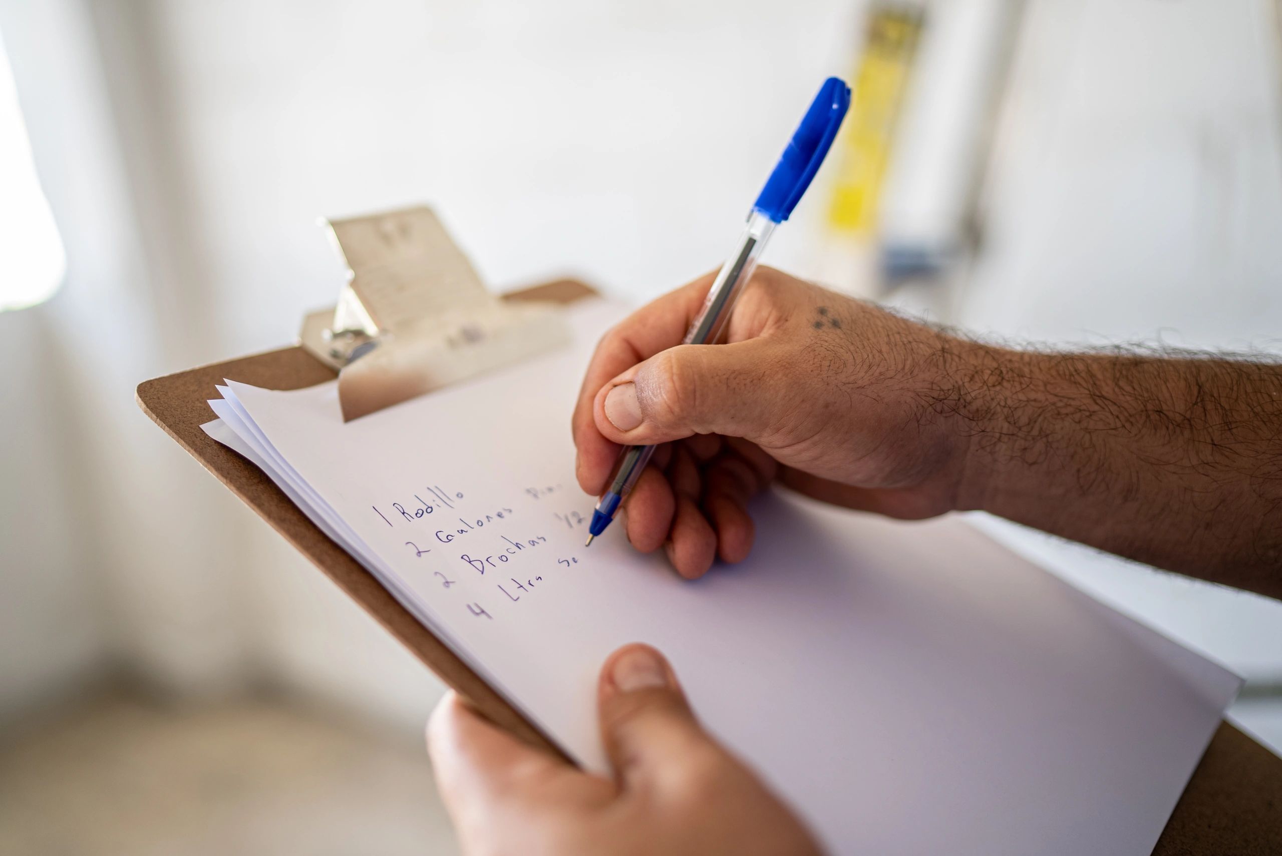Close-up of a person writing on a clipboard during a site inspection