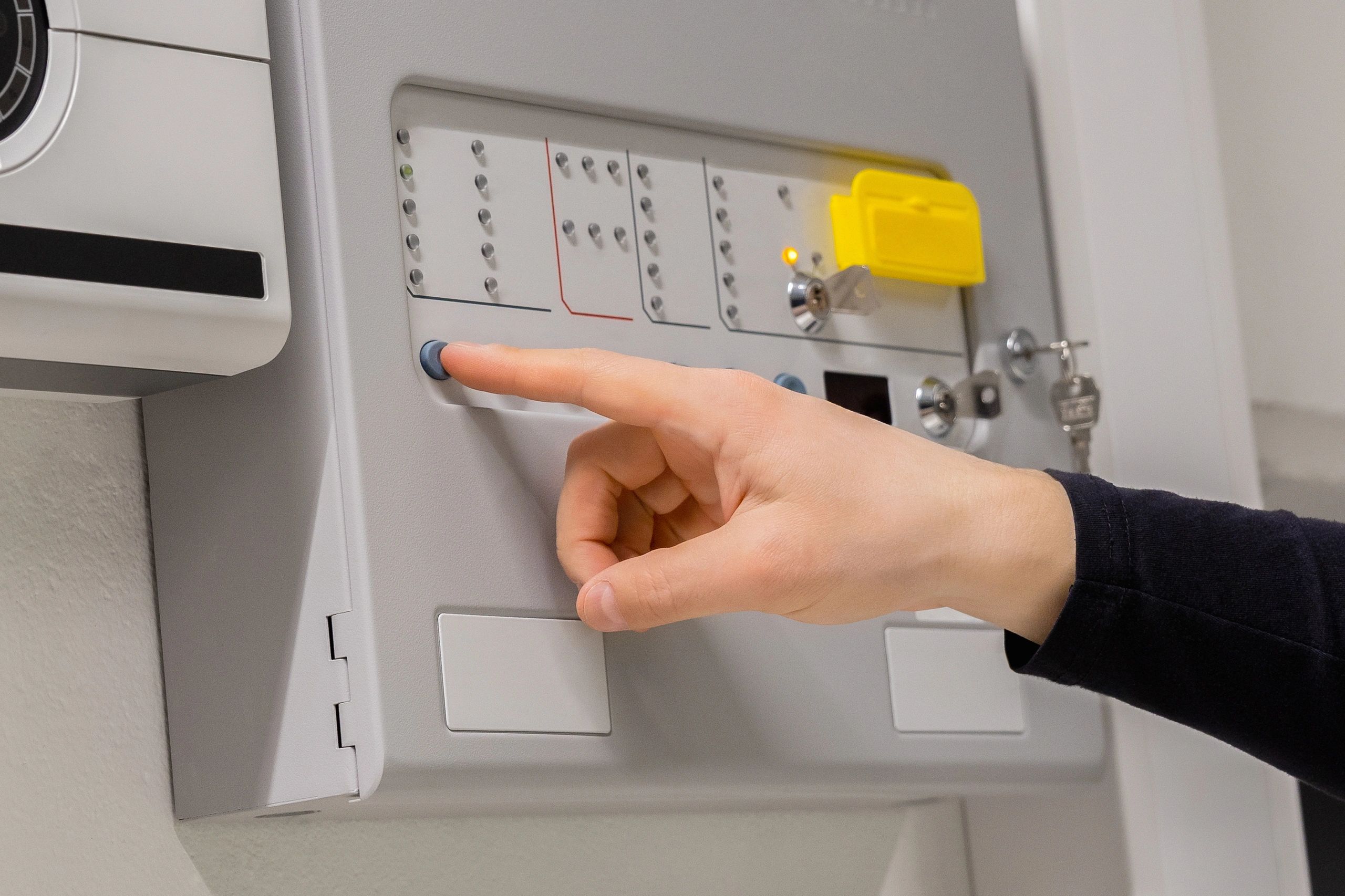Electrician checking a fire alarm panel in a technical room
