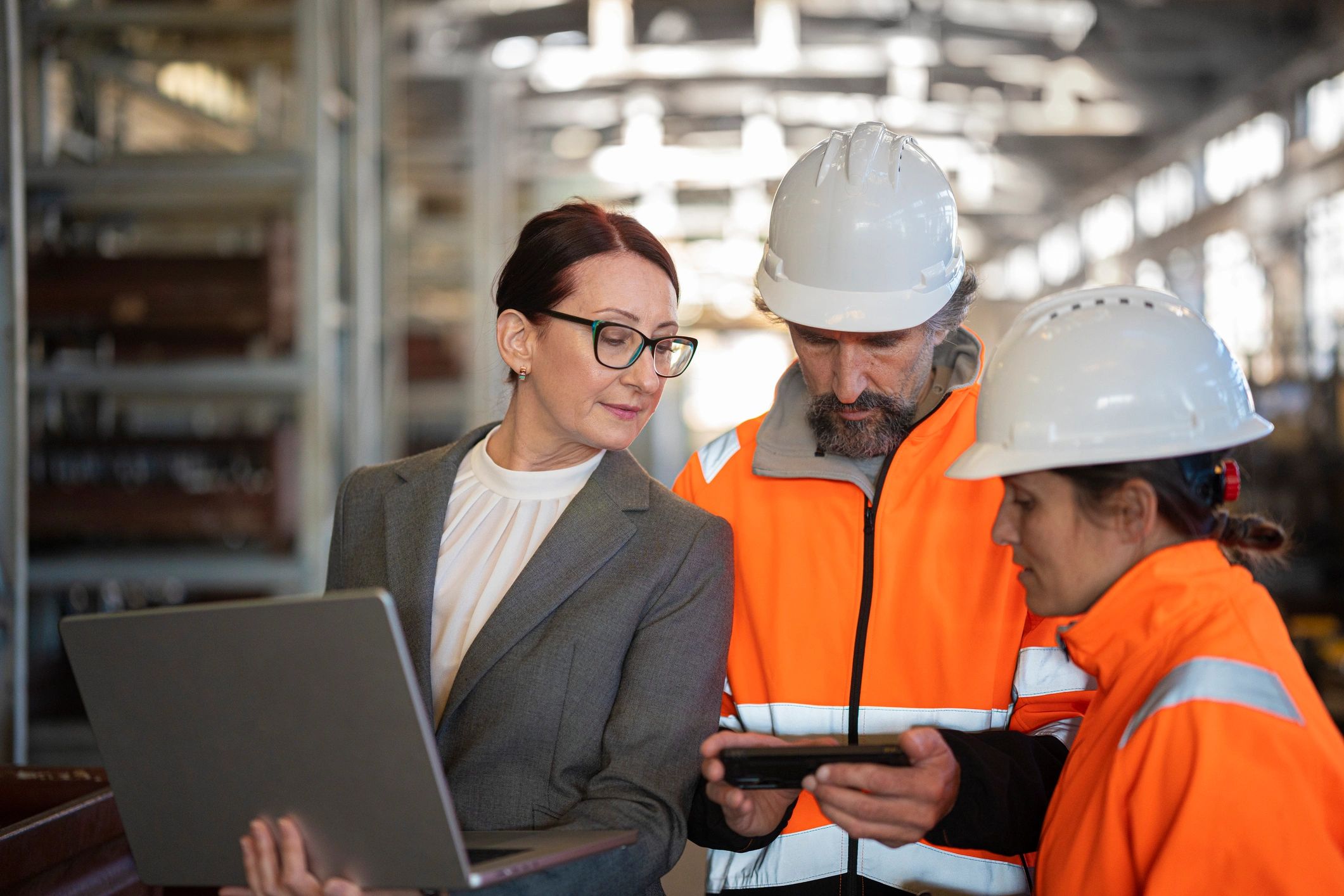 Safety team reviewing site conditions with a laptop on an industrial floor