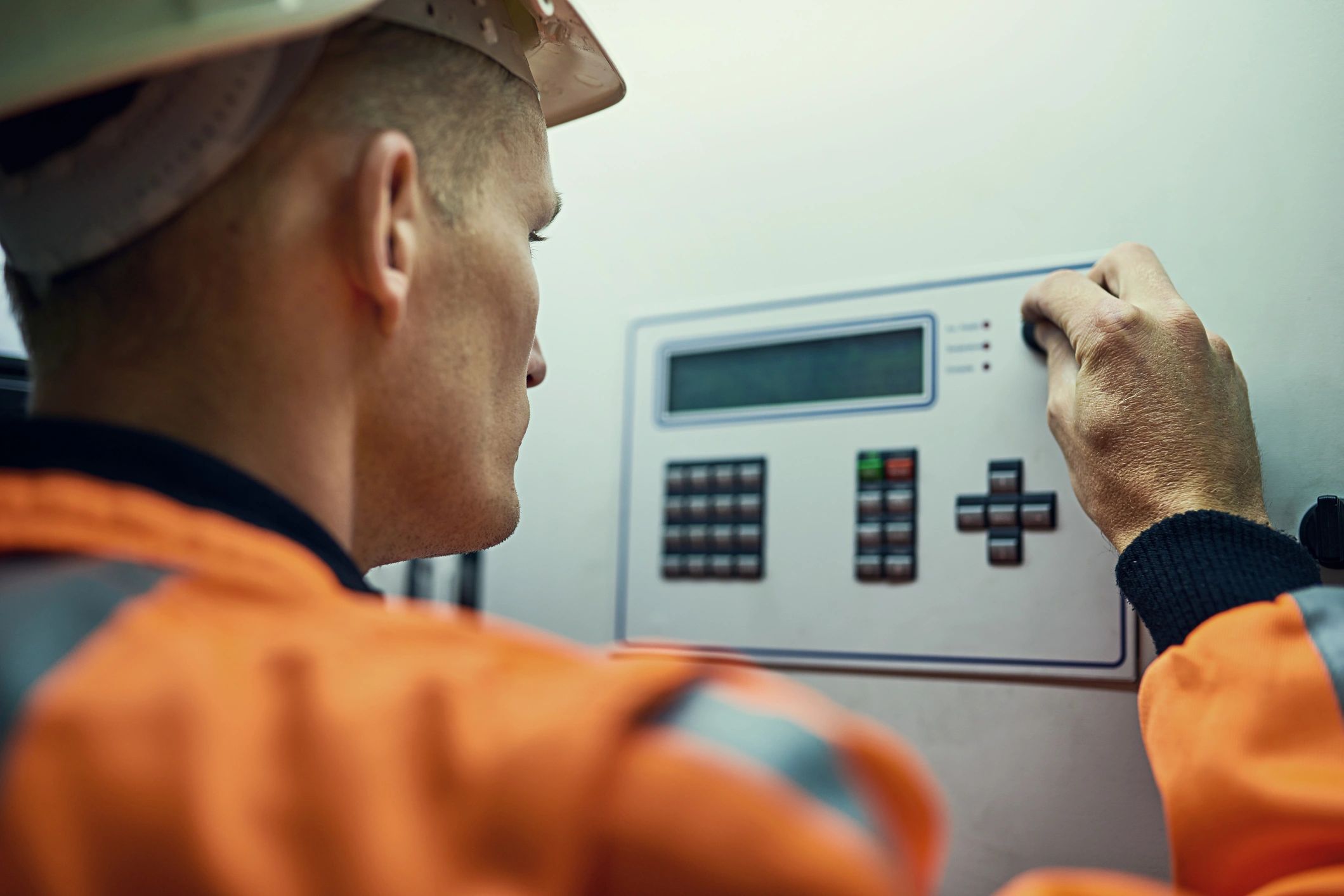 Engineer servicing industrial equipment with safety gear